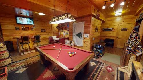 The Game Room offers fun and entertainment with a Custom Bar, Stove Fireplace, Infrared Sauna, Diner Booth, Barnwood Pool Table, Arcade Machine, HD Smart TV, stereo, and more!