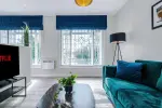 Spacious living room with comfortable seating and inviting atmosphere, perfect for relaxing or socialising during your stay.