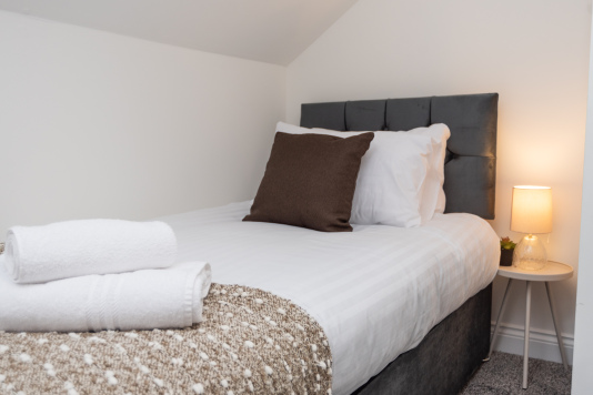 Two separate beds positioned on opposite sides of a privacy wall/divider