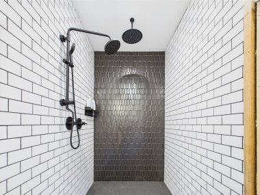 A black-tiled shower that feels indulgent and refreshing.