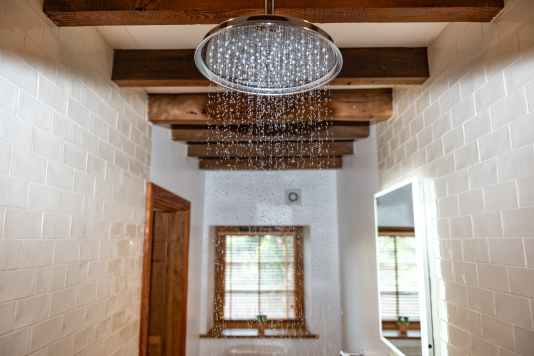 Ground-floor en suite with wide access, rainfall shower and toilet, plus complimentary shampoo, conditioner and body wash