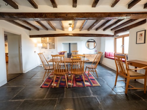 Spacious dining room with the original slate floor and exposed beamsve