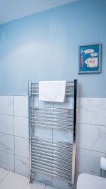 Clean, fresh and bright modern fitted bathroom, with walk in shower large mirror and a snuggly warm towel radiator.