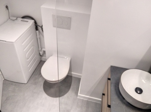 toilettes suspendues et machine à laver dans la salle d'eau