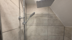 Step right into relaxation. The walk-in shower in this second-floor bathroom is spacious, modern, and beautifully designed.