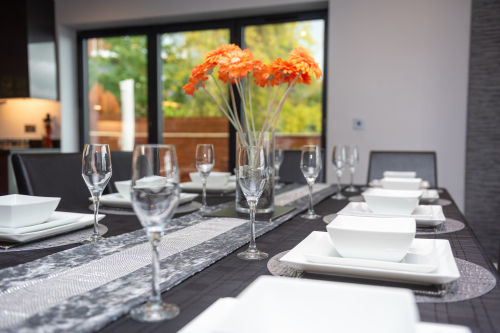 Beautifully set dining table with elegant dinnerware and everything needed for private dining or relaxed family meals.