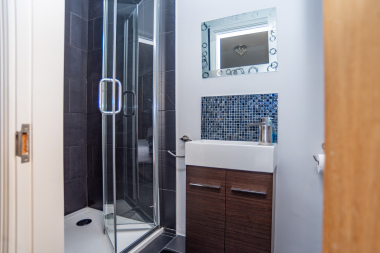 Another private ensuite featuring a sleek shower enclosure and single sink, ideal for comfort and convenience.
