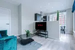 Spacious living room with comfortable seating and inviting atmosphere, perfect for relaxing or socialising during your stay.
