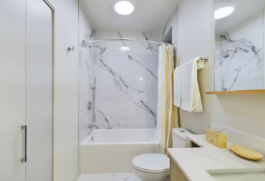 Refresh in this serene bathroom featuring marble-inspired tiles, a rainfall showerhead, and a spacious vanity. Soft lighting and sleek fixtures create a spa-like atmosphere, perfect for unwinding after a long day or starting your morning with calm.