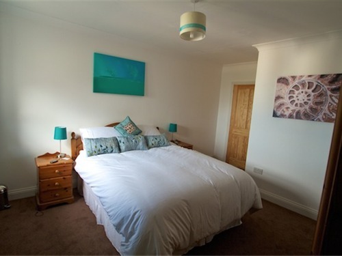 Master bedroom with king size bed, en suite bathroom and sea views