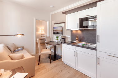 Wohnbereich mit Kochzeile, TV und Esstisch