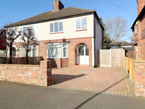 The property features a private driveway, providing convenient parking for guests. With a welcoming exterior and well-maintained surroundings, it’s the perfect start to your stay.