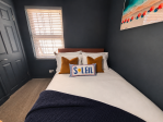 Comfortable second bedroom featuring a small double bed and built-in storage for your convenience.