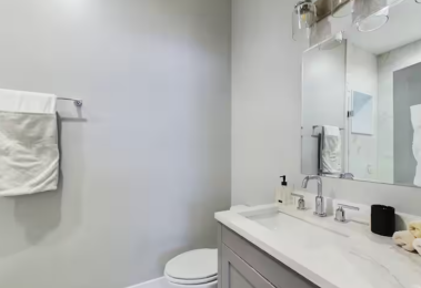 Modern full bathroom featuring a sleek vanity with ample counter space, a large mirror, and fresh towels. Enjoy a refreshing experience in the spacious glass-enclosed shower with premium fixtures. Clean, stylish, and designed for relaxation.