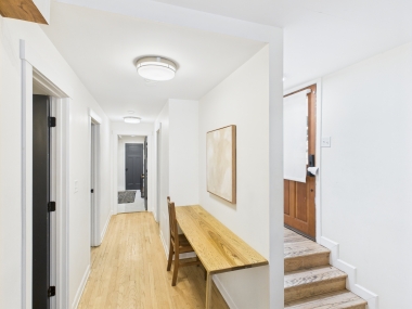 A bright hallway connecting the bedrooms and baths, designed to feel airy and uncluttered.