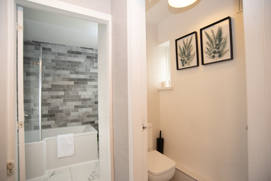 Welcoming bathroom with a full-size bath and over-bath shower, plus a separate WC for added convenience and flexible use during your stay.