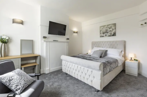 Luxury 3 Bedroom Apartment Hornchurch - Relax in style with our master suite featuring a sleek bed frame, desk and flat screen TV