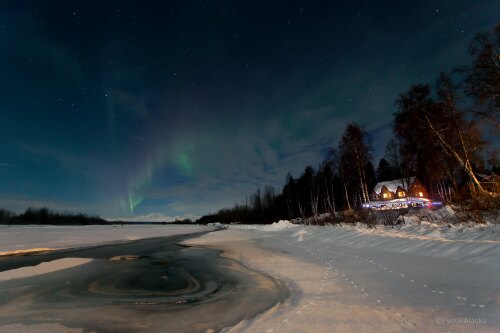 The northern lights dance above the lodge 
