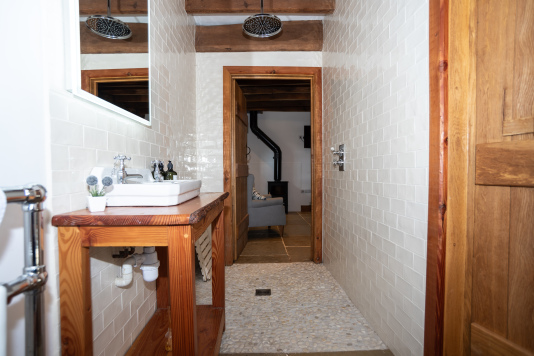 Downstairs en suite with powerful rainfall shower, sink and toilet — easy-access, user-friendly and lockable for privacy, with direct access to the living room