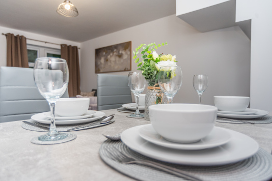 Spacious dining table fully set with cutlery, crockery and all essentials - perfect for shared meals or work sessions.
