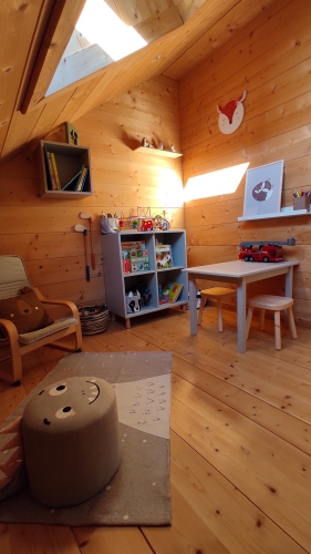 Salle de jeux pour enfants avec coin lecture, livres et jouets en bois