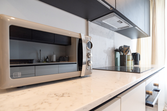 Well-equipped kitchen with microwave, kettle and cooking essentials.