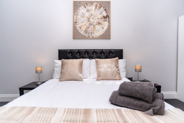 Another beautifully styled bedroom with hotel-crisp linens, creating a clean and relaxing retreat.