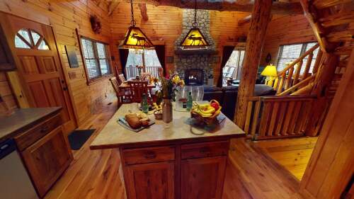 Full river rock fireplace and hand-peeled logs throughout the cabin. Main floor also features master bedroom with Smart HDTV, full bathroom, and reclining leather sofas.