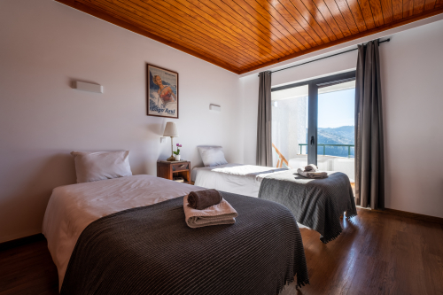 Room with two single beds and balcony overlooking the lake.