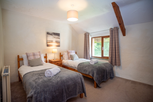 Comfortable Twin Bedroom - Soft grey throws, crisp white linens and a warm bedside lamp for a cosy night in after a day exploring Devon.