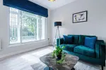 Spacious living room with comfortable seating and inviting atmosphere, perfect for relaxing or socialising during your stay.