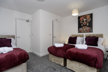Spacious ensuite bedroom with two zip-link king beds and a single bed