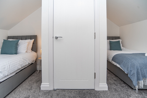 Modern top-floor bedroom with two single beds for a restful stay.