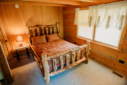 Main floor bedroom #1 with a queen size log bed