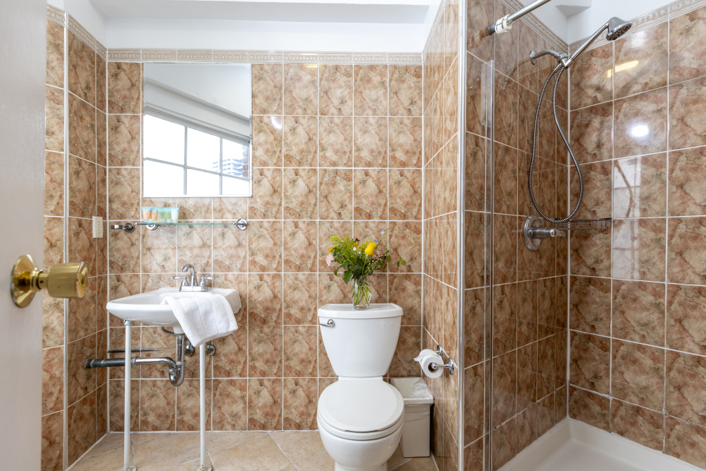 A bathroom with a toilet, sink, and shower