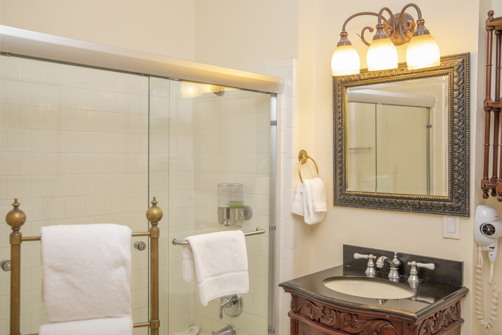 A bathroom with a shower, sink, and mirror.