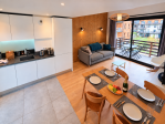 Vue d'ensemble comprenant la salle à manger, la cuisine, le salon avec canapé et la terrasse pour un séjour confortable.