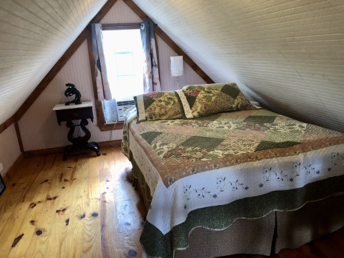 Queen bed in loft in Michelles log cabin