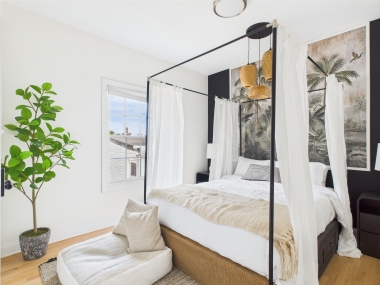 A serene bedroom accented with lush greenery and soft linens.