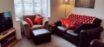 Living room with 2 x 2 seater sofas plus comfy armchair and foot stool. Additional seating available if necessary. New easy use Smart TV. Feature cosy fireplace. 