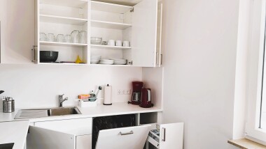 Voll ausgestattete Küche mit Herd, Backofen, Mikrowelle, Kühlschrank, Spülmaschine, Kaffeemaschine, Wasserkocher, Geschirr und Besteck – ideal für die Selbstverpflegung.