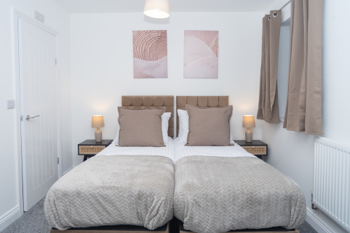 Master bedroom with zip-link beds that convert from two singles into a king, complete with private en suite — offering ultimate flexibility for any group