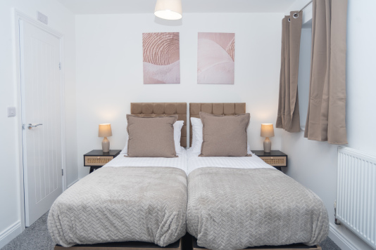 Master bedroom with zip-link beds that convert from two singles into a king, complete with private en suite — offering ultimate flexibility for any group