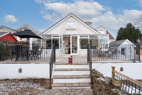 Outdoor patio area with table and chairs, plus a large rear conservatory and games room complete with a ping-pong table — perfect for family fun and relaxed evenings.