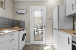 Kitchen with washing machine, microwave, kettle, oven and hob, fredge/freezer