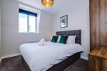 Spacious living room with comfortable seating and inviting atmosphere, perfect for relaxing or socialising during your stay.