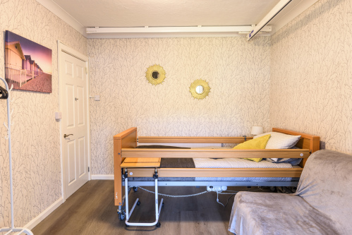 Accessible bedroom with a ceiling hoist and sofa bed