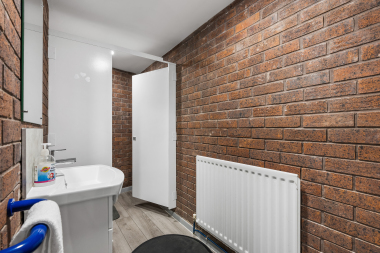 Bathroom in the lower ground floor, clean and tidy with industrial exposed brickwork