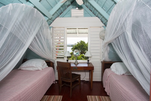 Upstairs bedroom with twin beds overlooking tennis court and Long Bay