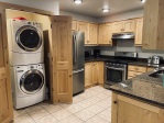 kitchen with washer and dryer, stainless steel appliances, granite countertops and real wood cabinets. High-end. 